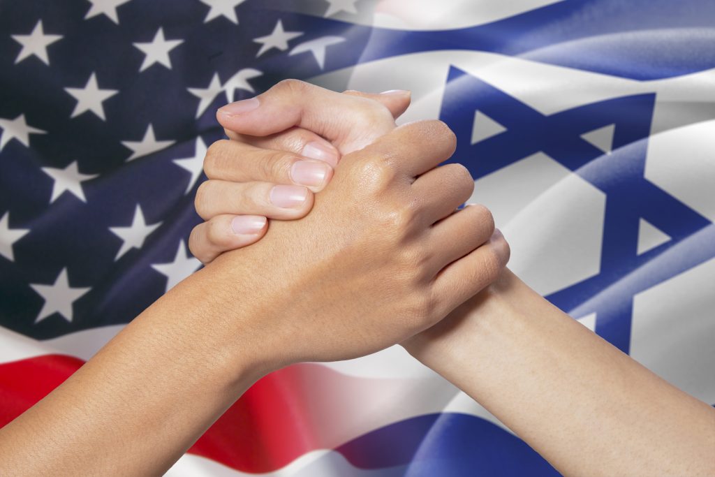 two women holding each other hands with the jewish and american flag in the background to symbolize two different coming together