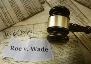 roe v. wade news headline with a gavel on a copy of the declaration of independence