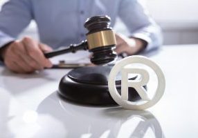Close-up Of Judge Striking Mallet On Trademark Copyright Symbol A