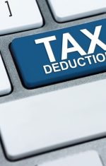 Zoomed in view of a keyboard that shows a big blue key that reads "TAX DEDUCTION"