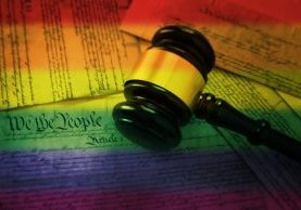 Court gavel on rainbow flag colored pages of the United States Constitution