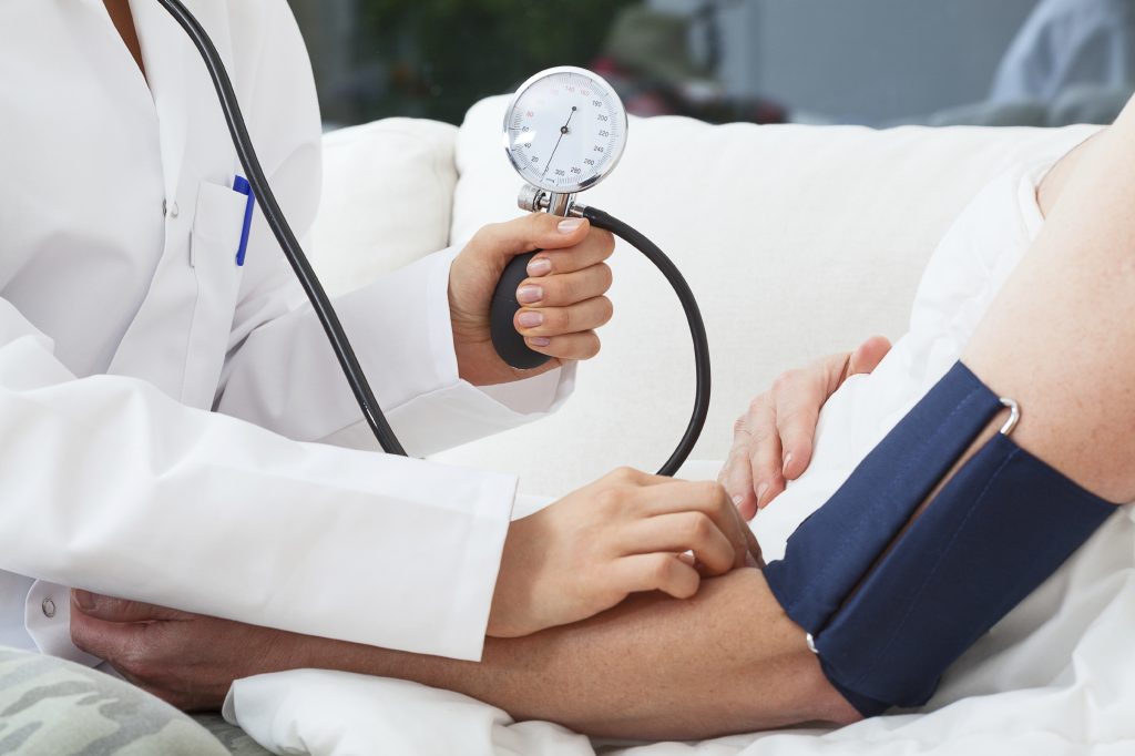 Measuring the blood pressure by doctor with pressure gauge