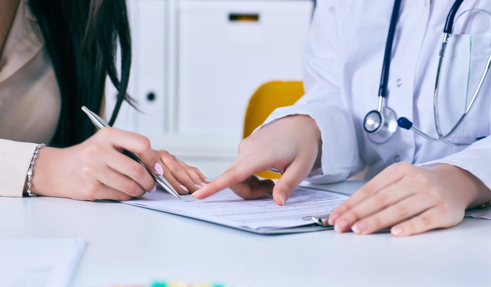 doctor with female patient signing papers
