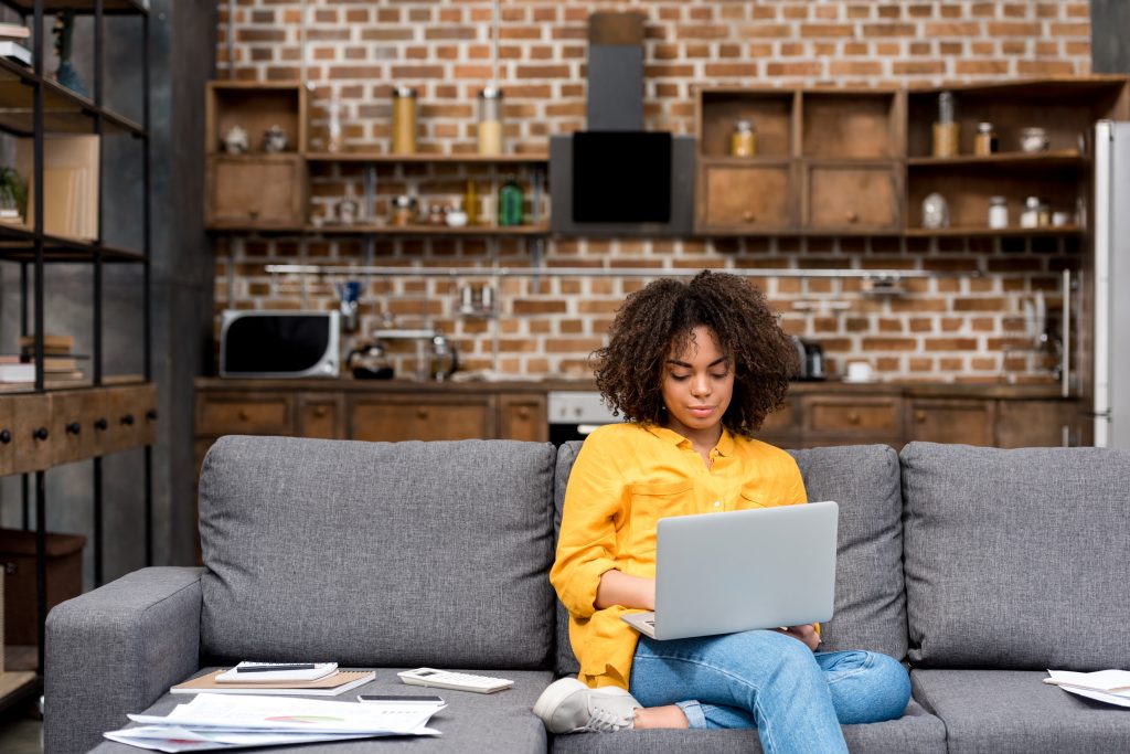 young woman working working with laptop on couch