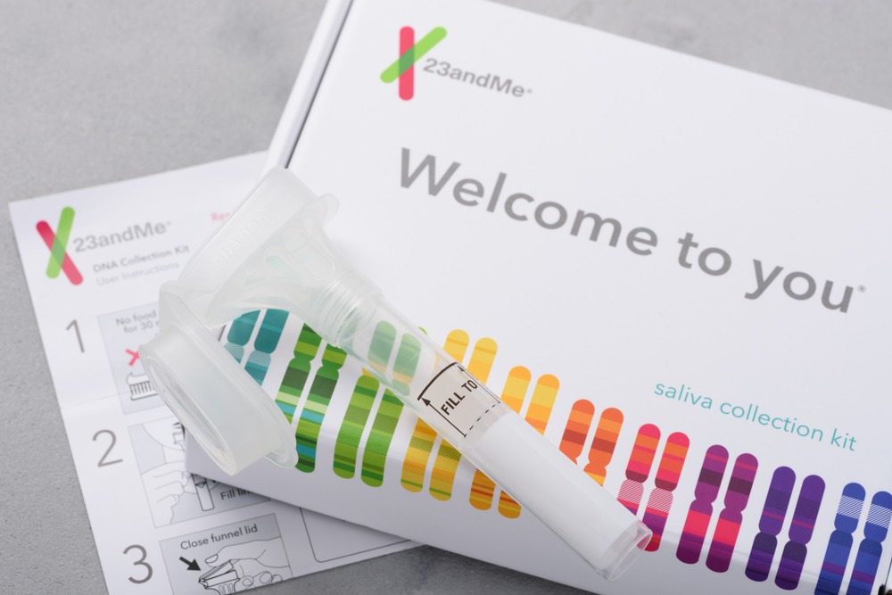 23andMe personal genetic test saliva collection kit, with tube, box and instructions. Illustrative editorial
