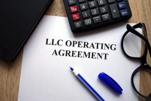 LLC operating agreement, pen, glasses and calculator on desk