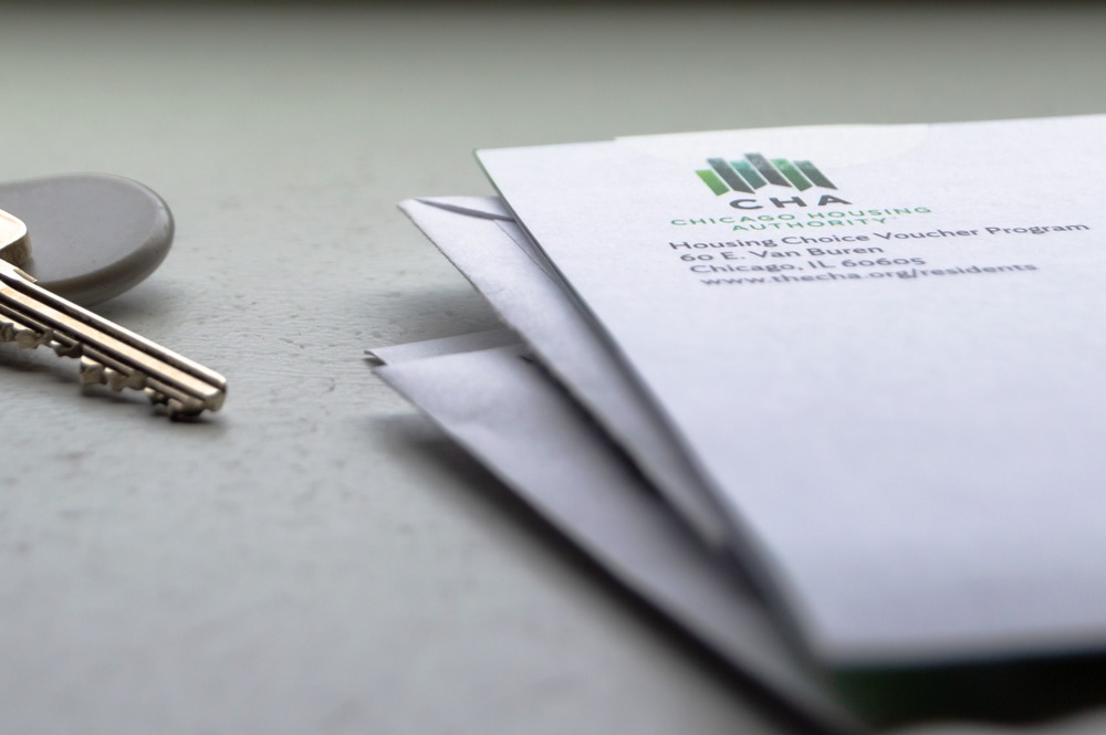 Chicago, USA-April 10, 2019: A letter or mail from Chicago Housing Authority is displayed with an apartment door key and key fob. Public housing assistance program, CHA, Housing and Urban Development