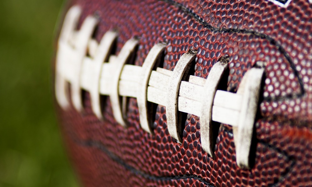 Close up of an american football against a black background