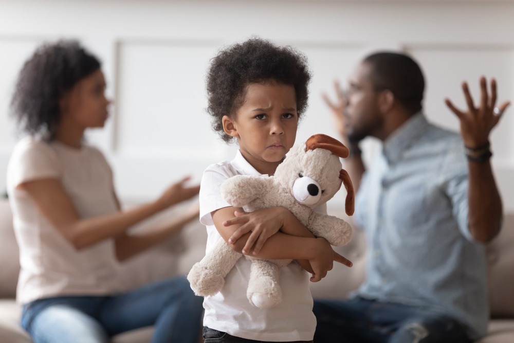 Stressed kid son feeling lonely, upset little african american boy holding embracing soft toy, suffering from parents quarrel, family conflicts, negative emotions, divorce or break up concept.