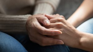 close up of two individual's hands clasped together