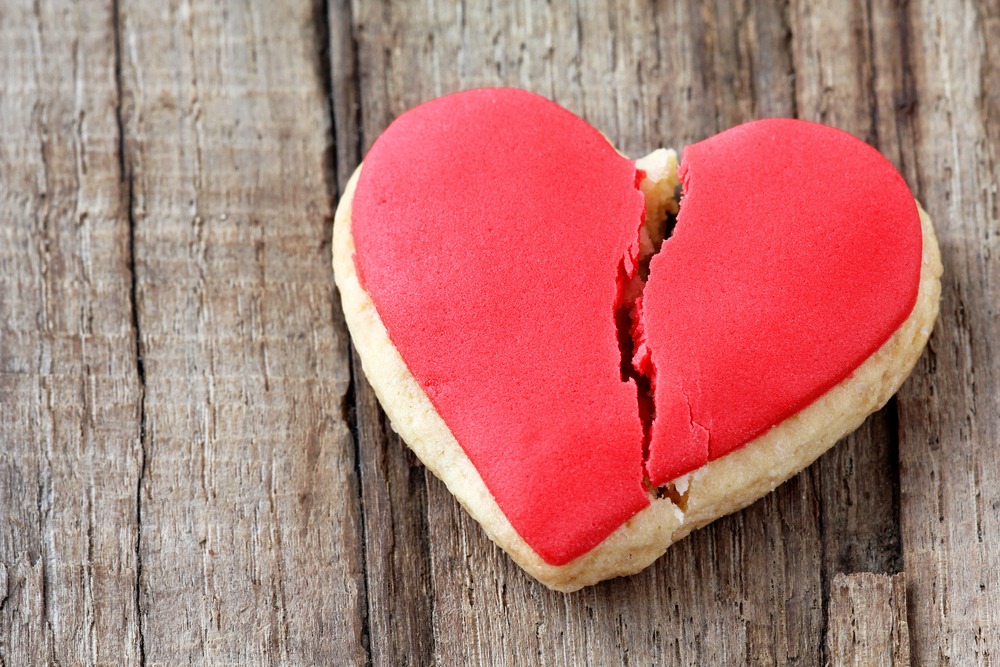 Cracked heart shaped cookie decorated with red icing