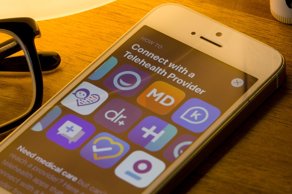 Assorted telehealth mobile app icons are seen from the App Store on an iPhone.