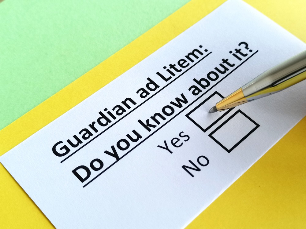 close up of a question: guardian ad litem: do you know about it? typed on a piece of white paper with yes and no check boxes with a pen hovering over the yes check box.