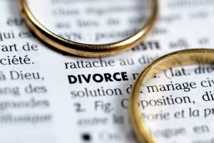 divorce concept with two wedding rings surrounding the word divorce