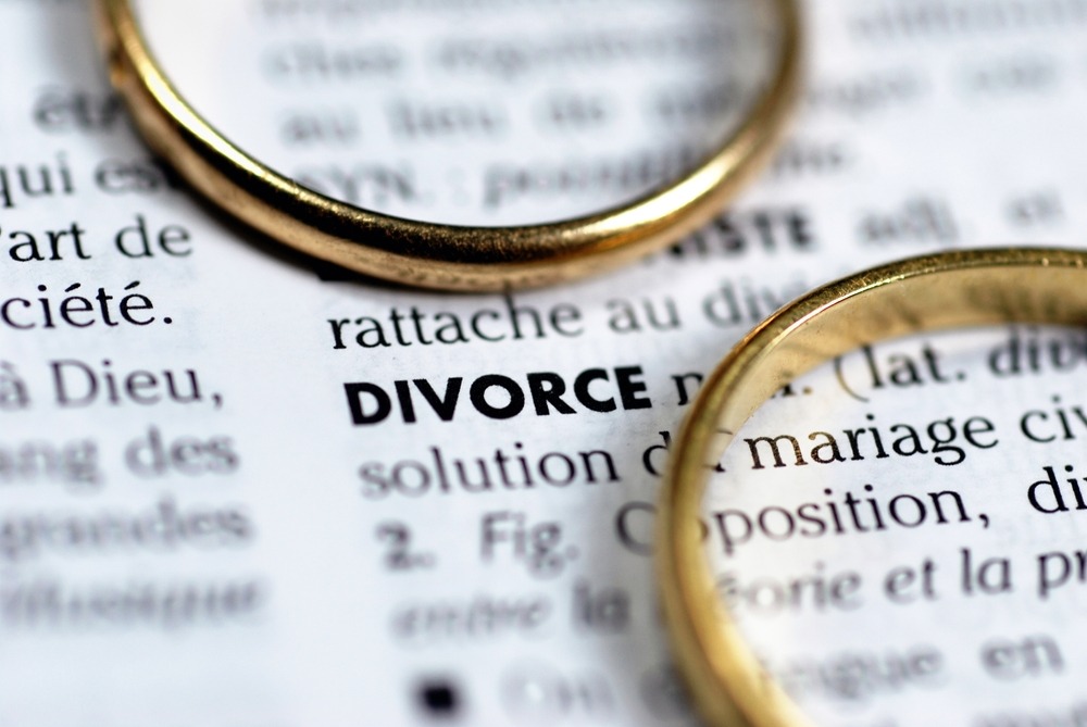 divorce concept with two wedding rings surrounding the word divorce