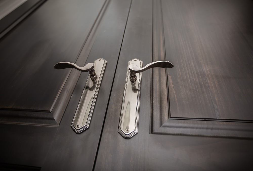 fragment of closeup view of a beautiful natural wood closed doors and stylish amazing door handles