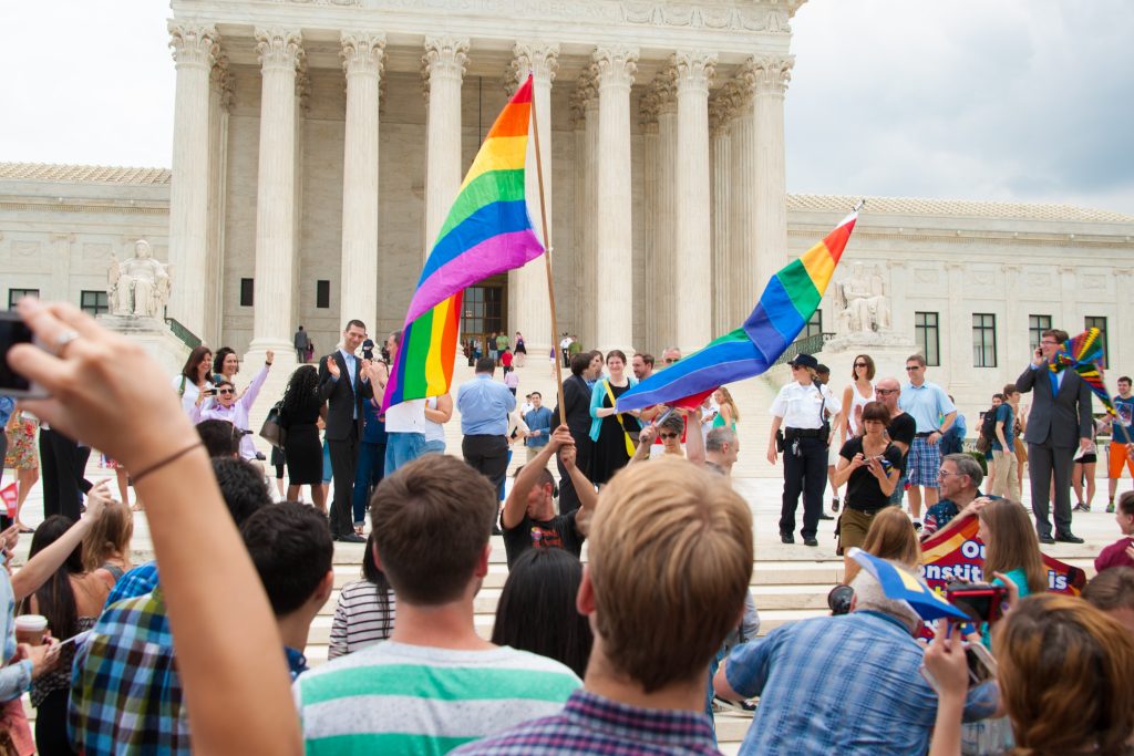 Crowd gathered outside of the Supreme Court with pride flags