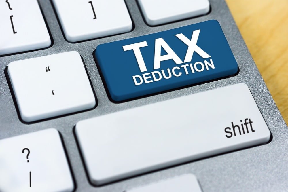 Zoomed in view of a keyboard that shows a big blue key that reads "TAX DEDUCTION"