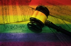 Court gavel on rainbow flag colored pages of the United States Constitution